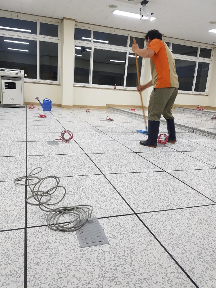 악세스플로어의 전도성 타일에 전도성 왁싱하는 모습