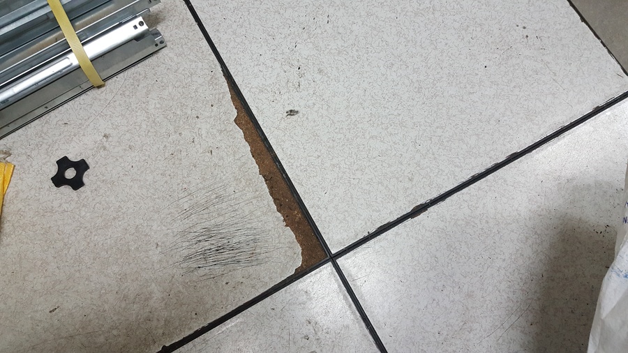 유지관리 부실로 인해 전도성 타일 테두리가 파손되고 마감재가 들떠 보행 안전을 위협하는 악세스플로어 상태