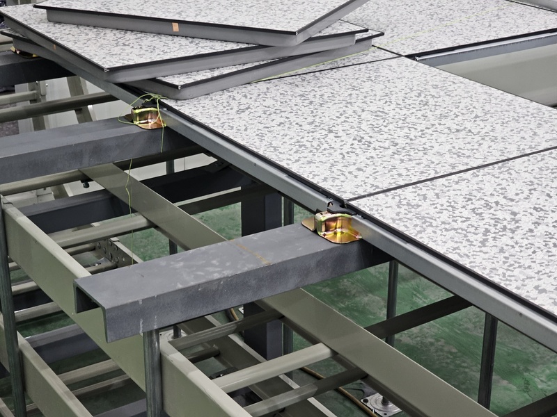 고상 악세스플로어 시공 현장에서 고하중 장비 안착을 위해 선행 설치된 강재 프레임(Base-Frame)과 악세스플로어 지지대 및 판넬의 정밀 결합 공정 사례